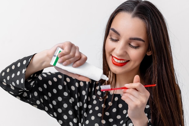 Image of pretty female brushing her teeth with tooth brush and tooth paste. Selective focus. Teeth care concept. Oral care concept.