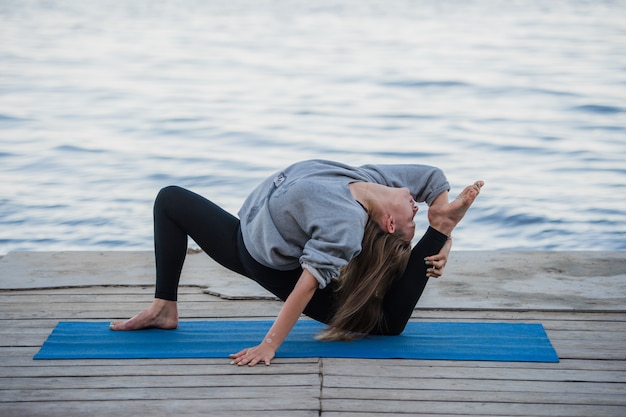 Image of a pretty woman doing yoga at the lake