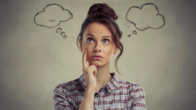 Image of serious woman with brown hair in bun with face upward thinking or dreaming posing