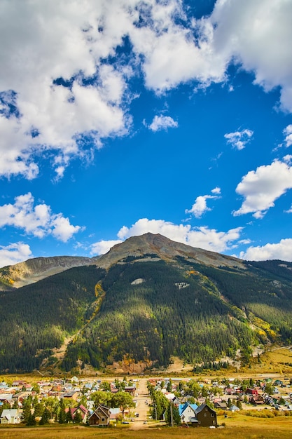 Image of Small mining town in the country with tall mountain range and blue sky