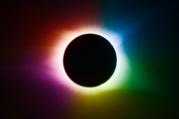 Image of Solar eclipse with rainbow of colors and a black center