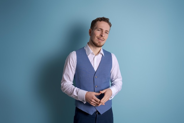 Image successful man in formal wear smiling at camera isolated on blue