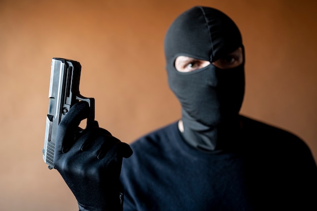 Image of a thief with balaclava and gun in hand