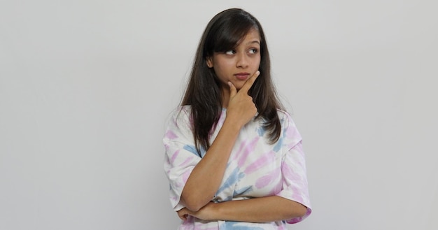 Image of thinking young girl standing isolated over grey background