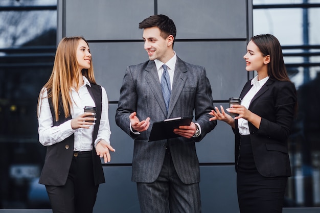 Image three business partners in black elegant suit talking and working together while discussing new strategy