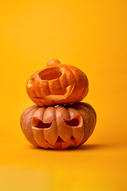 Image of two halloween pumpkins on empty orange background