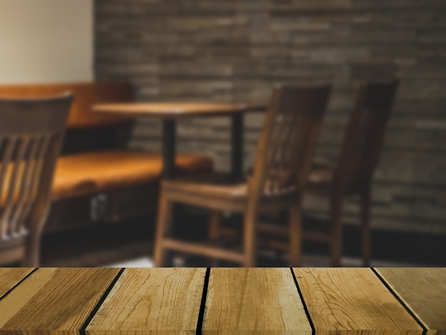 Image of wooden table in front of abstract blurred background of indoor restaurant chairs