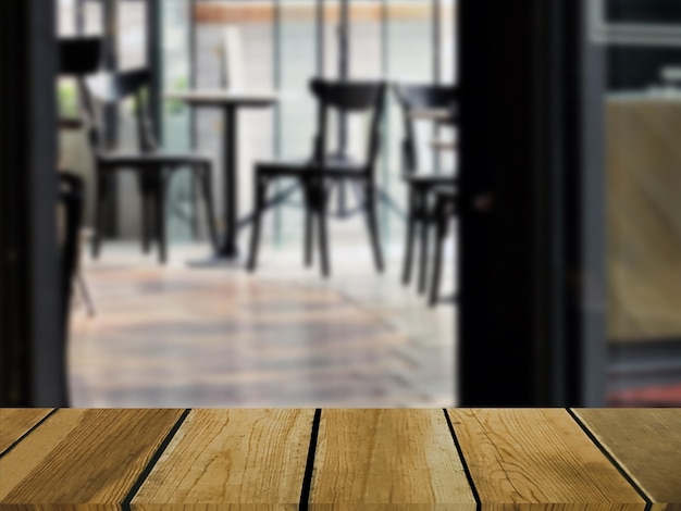 Image of wooden table in front of abstract blurred background of indoor restaurant chairs