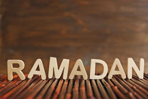 Photo image of word ramadan on wooden background close up