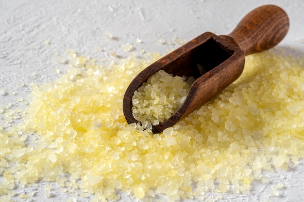 Image of yellow bath salts in wooden spoon