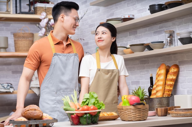 Image of young Asian couple cooking in the kitchen