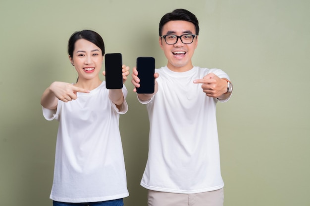 Image of young Asian couple using smartphone