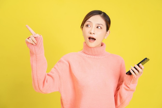 Image of young Asian girl using smartphone on background