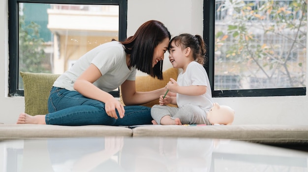 Image of young Asian mother and daughter at home