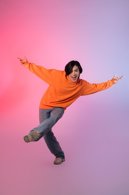 Image of a young Asian person dancing on a neon colored background