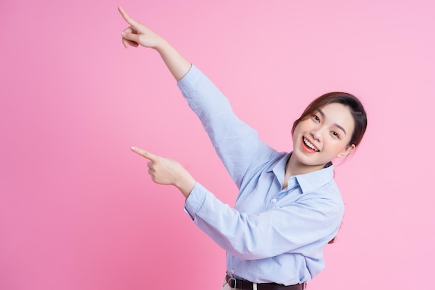 Image of young beautiful Asian girl posing on pink background