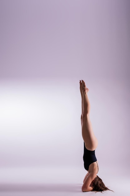 Image of young plump female doing acrobatic stunt studio shot