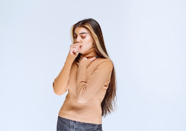 Image of a young woman model in brown sweater standing and posing.