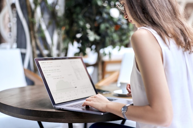 Image of a young woman using a laptop to work with documents