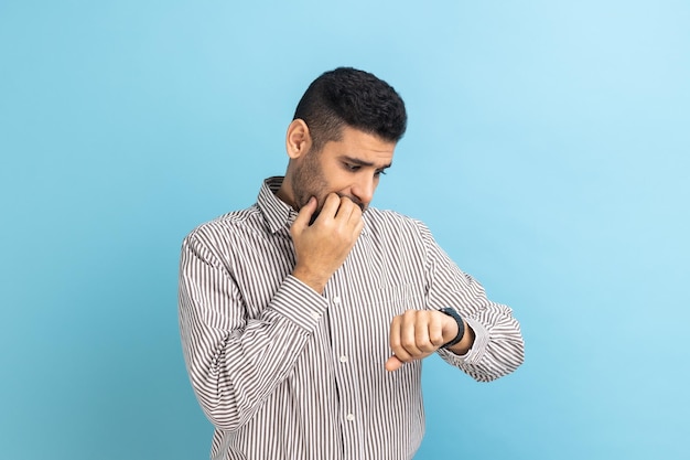 Impatient businessman pointing finger on his wrist watch with nervous face time is out deadline