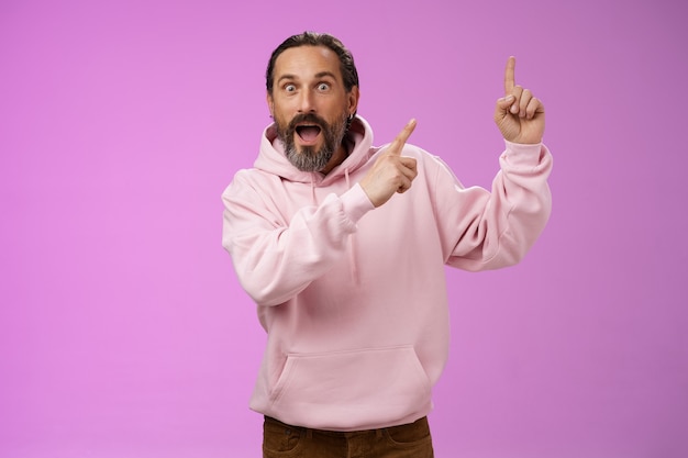 Impressed shocked exctied cool hipster mature s man bearded grey hair in pink hoodie retelling incredible story