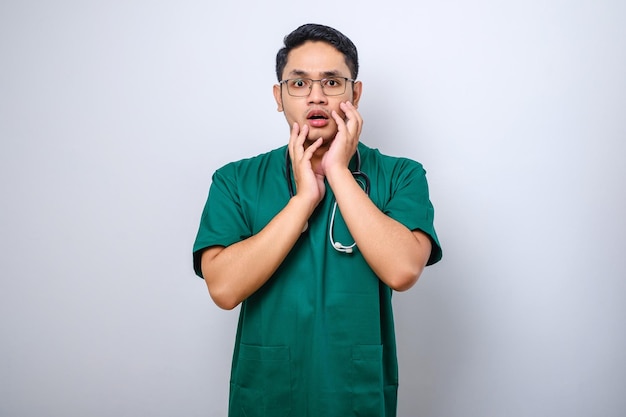 Impressed and surprised asian male nurse or doctor in scrubs drop jaw and stare at camera speechless