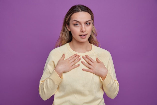 Impressed young girl pointing at herself with hands 