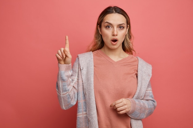 Impressed young girl pointing up 