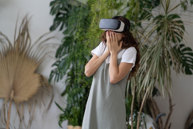 Impressed young woman feeling excited while testing vr headset in home garden