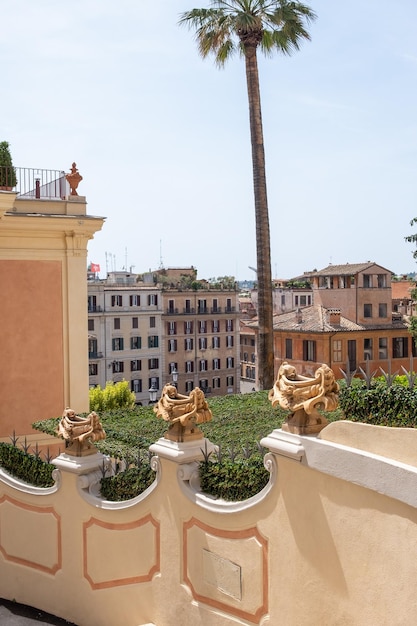 Impressive view to ancient buildings in Rome with renovated building wall with gray metal fence spik