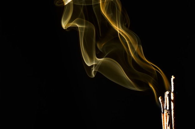 Incense burning over black background