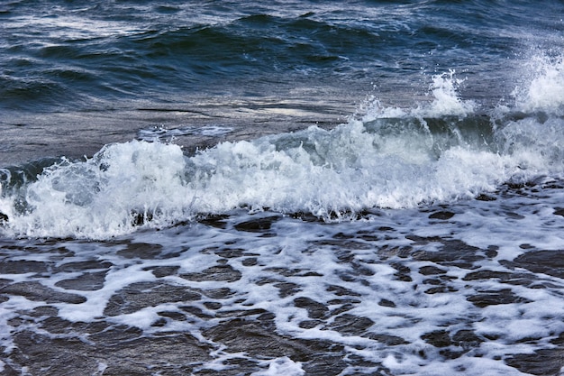 An incoming wave close up Storm waves at sea Dark sea strong waves with bright white sea foam