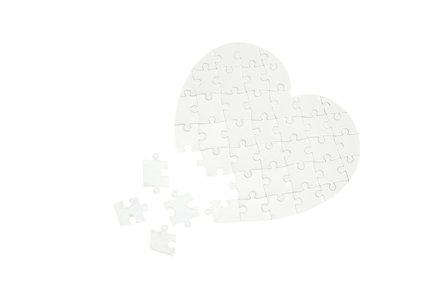 Incomplete jigsaw puzzle in a shape of a heart isolated on white