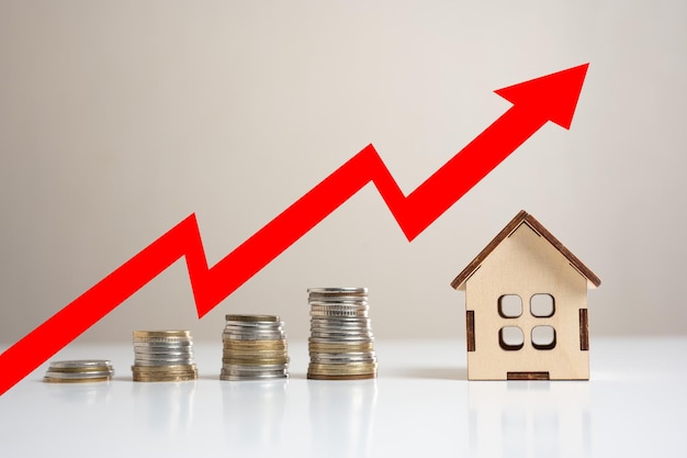 Increasing cost of housing High demand for real estate Growth of rent and mortgage rates Miniature wooden house Stacked coins and red arrow up Crisis in rental and real estate market