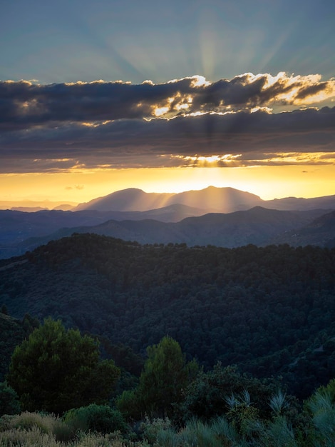 Incredible landscape of the mountains of Malaga with sunset in the cloudy sky