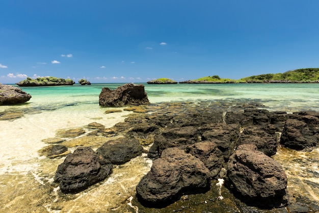 Incredible shape of coastal rocks. Emerald green sea and islets on background.  Iriomote island