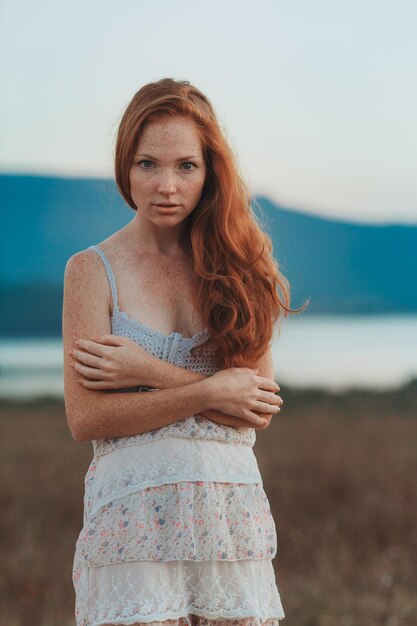 Incredible young woman with long curly hair and freckles face