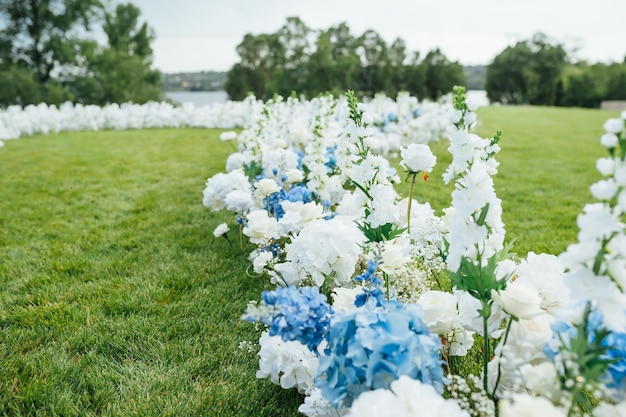 Incredibly beautiful outdoor ceremony on green grass and wooden chairs and fresh flowers Wedding day