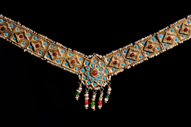 An India vintage jewelry pendant with precious stones on a black background