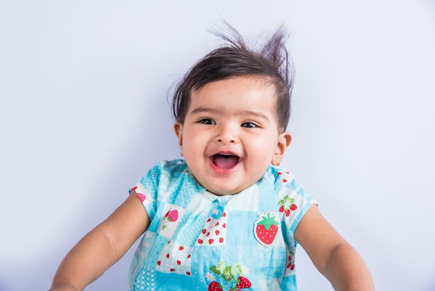 Indian baby playing with toys or blocks, asian infant playing with toys on white background, indian baby girl playing with toys, indian toddler playing with toys while lying on floor