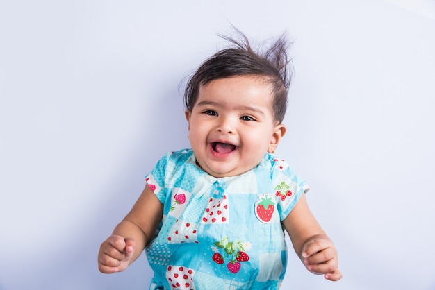 Indian baby playing with toys or blocks, asian infant playing with toys on white background, indian baby girl playing with toys, indian toddler playing with toys while lying on floor