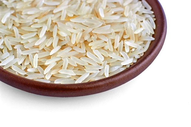 Indian basmati rice in a clay ceramic bowl closeup isolated on a white background