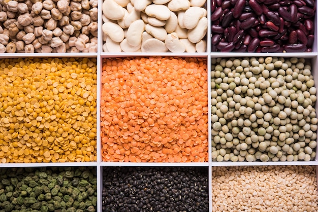 Indian Beans,Pulses,Lentils,Rice and Wheat grain in a white wooden box with cells, selective focus.