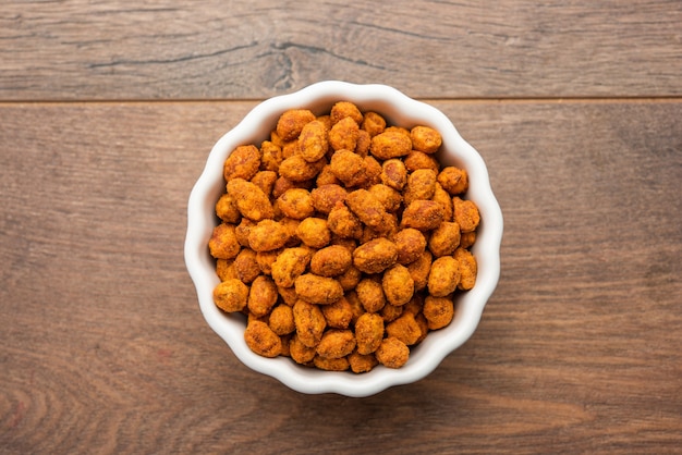 Indian besan coated crunchy and spicy masala peanuts or mungfali served in a bowl or plate