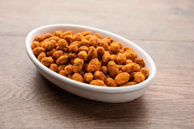 Indian besan coated crunchy and spicy masala peanuts or mungfali served in a bowl or plate