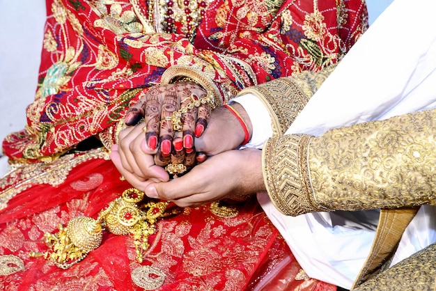 Indian bride and groom39s hand being tied together before the wedding rituals