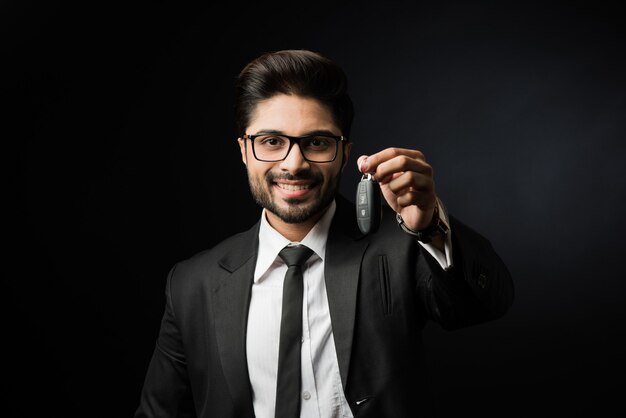 Indian businessman with Car Keys, standing isolated over black background