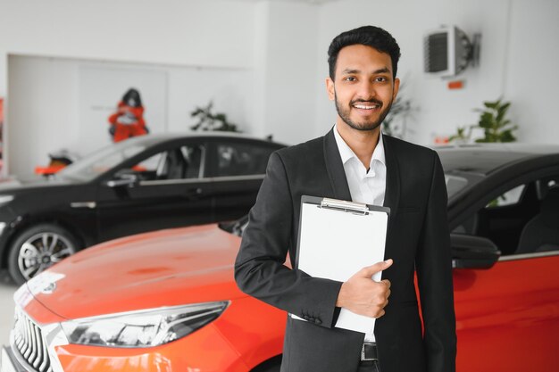 Photo indian cheerful car salesman at showroom