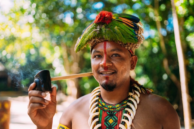 Indian chief from the PataxÃ³ tribe smoking pipe 