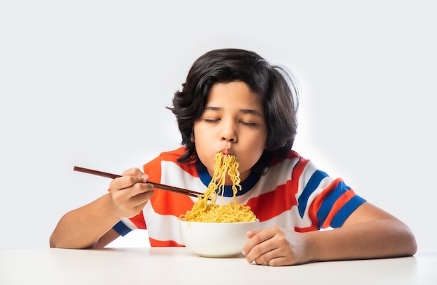 Indian child eating delicious noodles